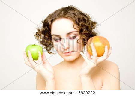 Hermosa chica rizada con dos frutas