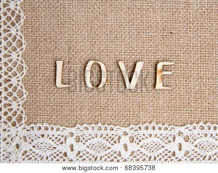 Word love and lace ribbon over burlap