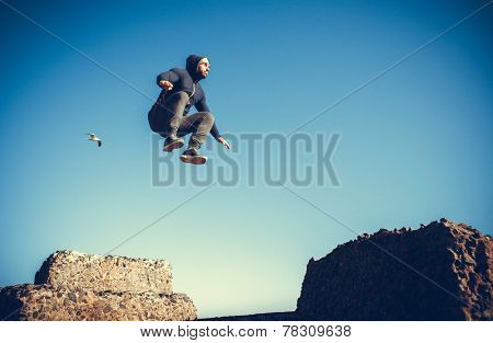 man performs freerunning jump on stones