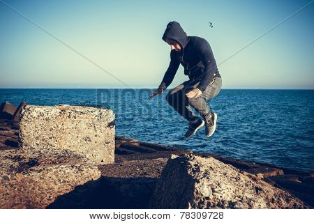 man performs freerunning jump on stones