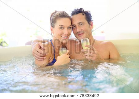 Romantic couple drinking cahmpagne in hot tub
