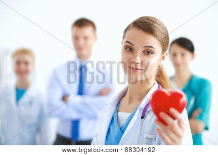 Female doctor with stethoscope holding heart .