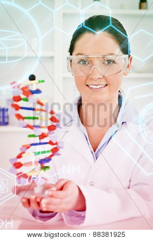 Science and medical graphic against portrait of a cute scientist showing the dna double helix model