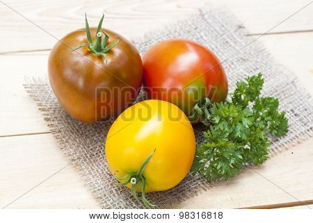 Assorted tomatoes: orange, pink, black tomatoes with parsle