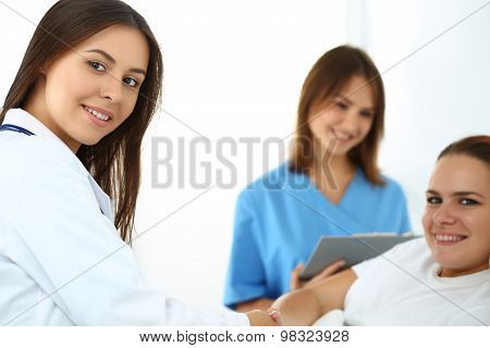 Female Doctor Shaking Hands With Patient Lying In Bed
