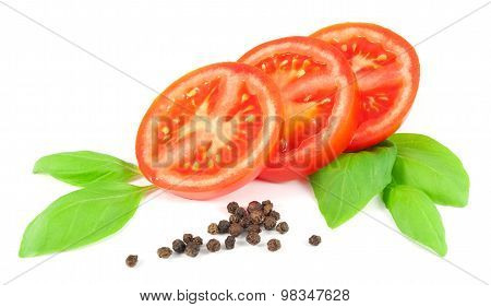 Sliced tomato with basil leaves and black pepper isolated on white