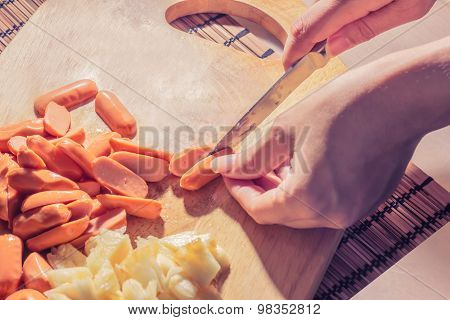 Preparing sausage and vegetables woman hands vintage tone.