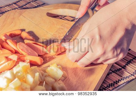 Preparing sausage and vegetables woman hands vintage tone.