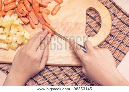 Preparing sausage and vegetables woman hands vintage tone.