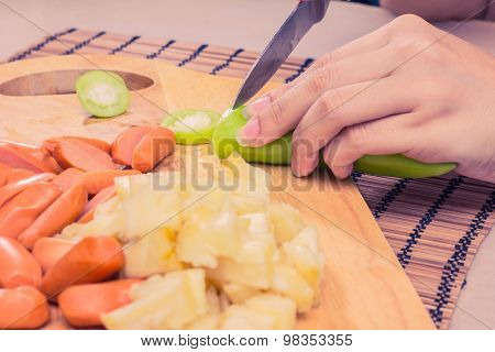 Preparing sausage and vegetables woman hands vintage tone.