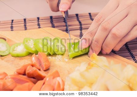 Preparing sausage and vegetables woman hands vintage tone.