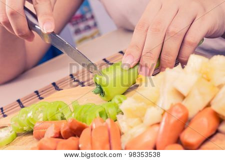 Preparing sausage and vegetables woman hands vintage tone.