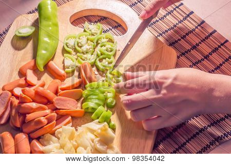 Preparing sausage and vegetables woman hands vintage tone.