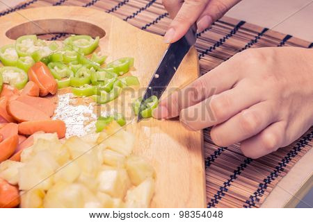 Preparing sausage and vegetables woman hands vintage tone.