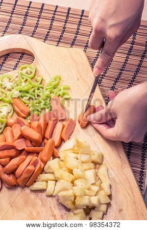 Preparing sausage and vegetables woman hands vintage tone.