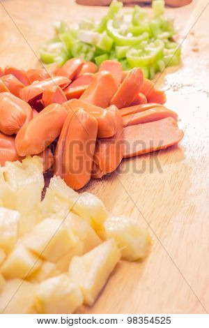 Preparing sausage and vegetables woman hands vintage tone.