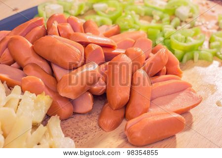 Preparing sausage and vegetables.