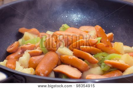 Preparing sausage and vegetables.
