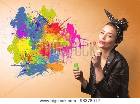 Cute girl blowing bubble spalsh graffiti into wall