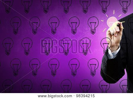 Close up of hand darwing light bulb with marker
