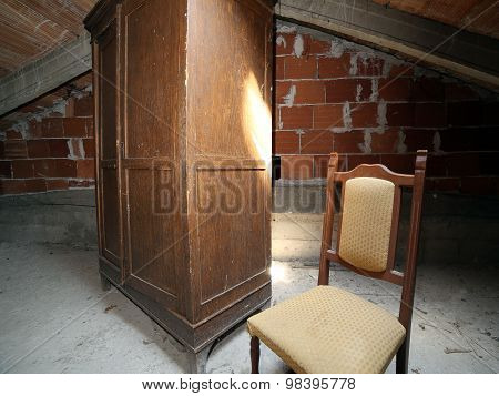 Wooden Wardrobe And An Antique Chair In The Dusty Attic