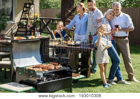 Happy Multi-generational Family Having Lunch On Patio At Sunny Day