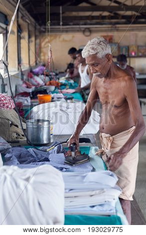 COCHI, INDIA - JANUARY 21, 2016: Indian man working hard at Dhobi Ghat in Fort Cochin, South India
