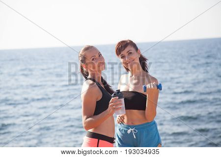 Fitness Girls With Shaker And Dumbbells On The Beach 1