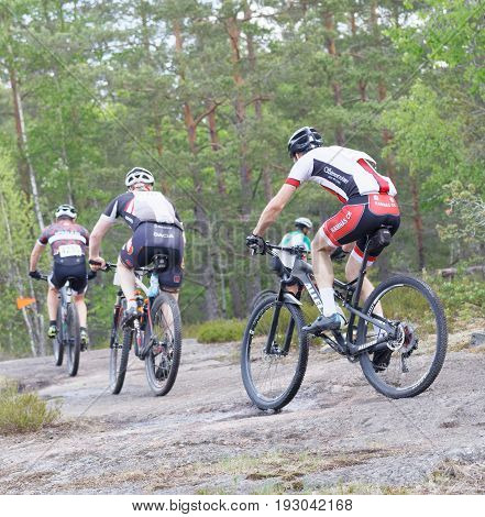STOCKHOLM SWEDEN - JUNE 11 2017: Rear view of group of mountain bike cyclists in the forest at Lida Loop Mountain bike Race. June 11 2017 in Stockholm Sweden