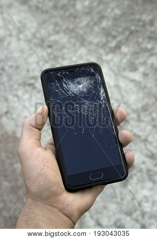 The guy takes the broken phone off the floor