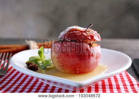 Plate with tasty baked apple on table, closeup