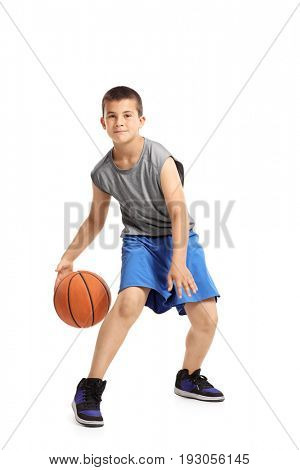 Full length portrait of a kid playing with a basketball isolated on white background