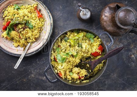 Indian Vegetable Biryani with Sweet Pepers and Zucchini as close-up in a frying pan 