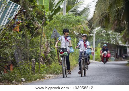 An Binh Island, Vietnam - March 25, 2017 : Vietnamese pioneers go home from school by bicycles on An Binh island, Vinh Long, Vietnam
