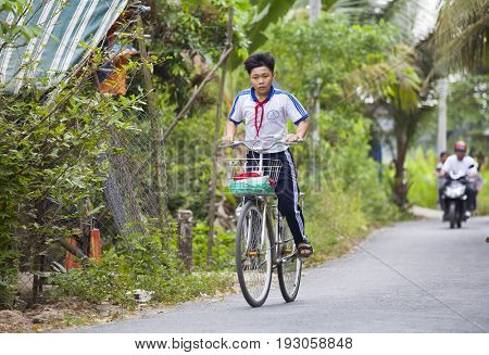 An Binh Island, Vietnam - March 25, 2017 : Vietnamese pioneers go home from school by bicycles on An Binh island, Vinh Long, Vietnam