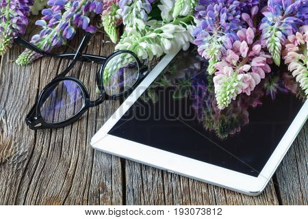 glasses on tablet and flowers on it