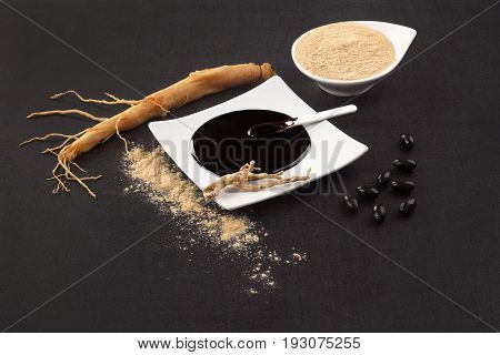 Healthy Ginseng supplements. Fresh root pills extract and powder on black background.