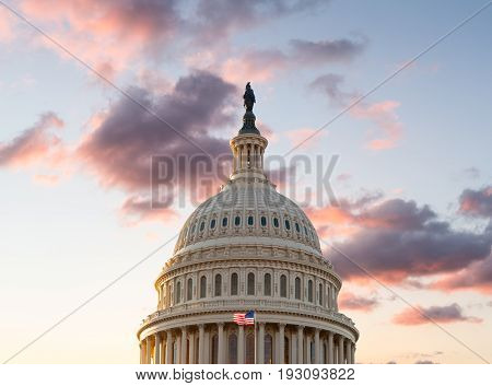 US flag flies in front of the US Capitol in Washington DC as the sun rises at dawn on a new day
