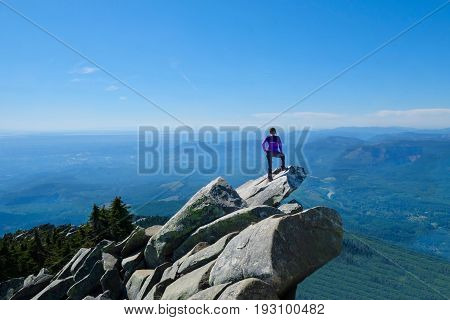 Woman in pose of success on mountain top. Mount Pilchuck. Cascades Mountains. Seattle. Washington. United States.