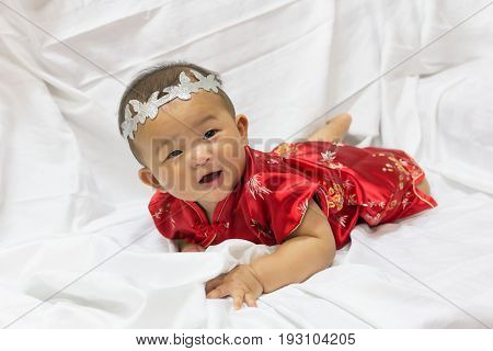 Asian cute new born girl baby with gesture of congratulation happy chinese new yeras.