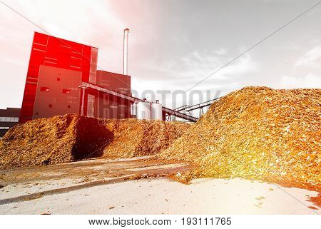 Bio Power Plant With Storage Of Wooden Fuel Against Blue Sky