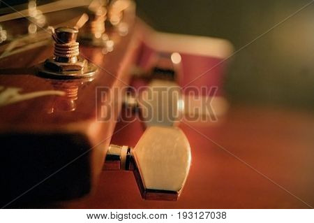 Extreme close-up of an acoustic guitar in a low-light setting.