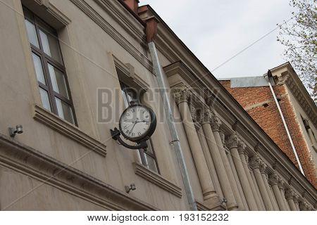 The wall clock on the outer bracket is attached to the wall and is located at the Street have a black color of the rim and white color of the dial are made antique