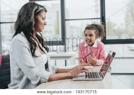 Side View Of Businesswoman Typing On Laptop While Daughter Getting Bored, Work And Life Balance Conc