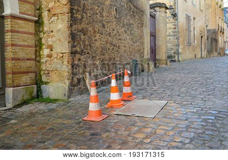 Orange cones on a medieval street in France