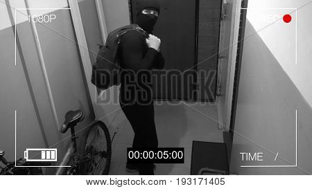 surveillance camera caught the robber in a mask running off with a bag of loot, shows the camera the middle finger.