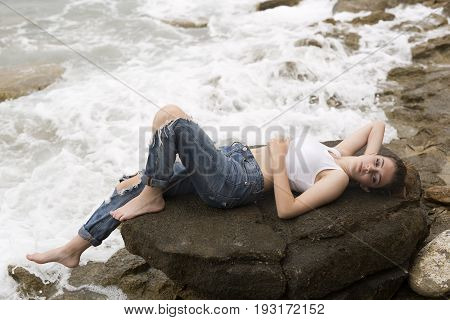Teenage Girl Lying On The Rocks
