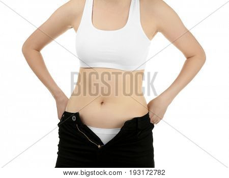 Beautiful young woman in undersized pants on white background, closeup. Diet concept