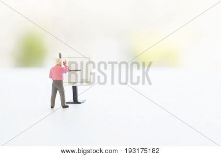 A conceptual photo with a toy engineer or other professional  at the empty drawing board with a place for your text. Focus on a figurine of a human.