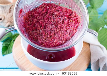 Preparation of berry jam on a wooden background